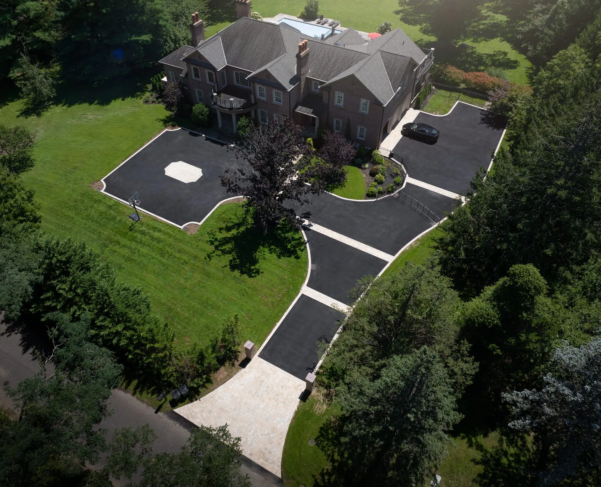 Aerial view of grand estate driveway approach with paver borders in Lloyd Harbor