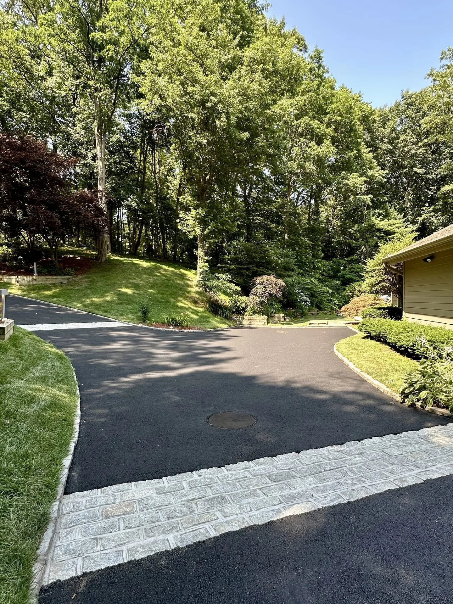 Curved Belgian block estate driveway through wooded Gold Coast property